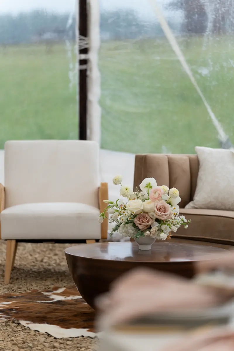 A cream armchair, a brown sofa and a dark wood coffee table on a brown and white cowhide rug A cream armchair, a brown sofa and a dark wood coffee table on a brown and white cowhide rug