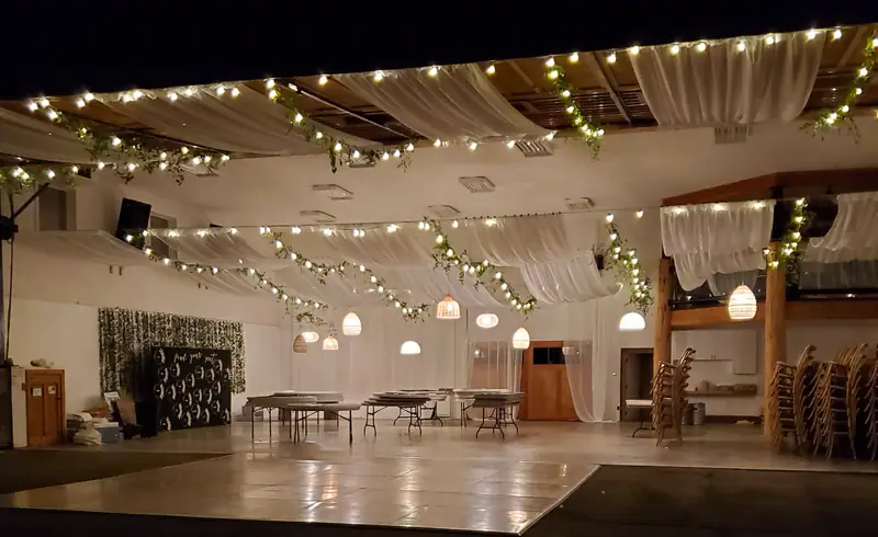 A wood dance floor laid in the middle of a decorated reception hall, ready for the party